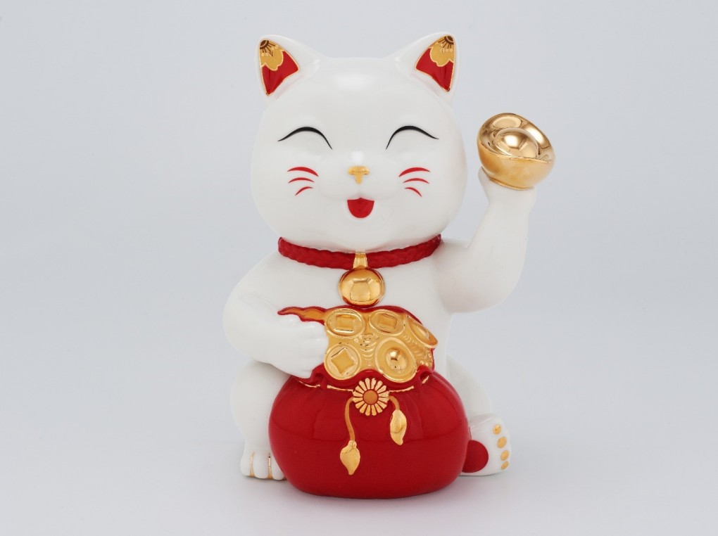 Tượng mèo Tài Lộc đeo vòng lục lạc vàng ngụ ý lời chúc tài lộc và phúc lành